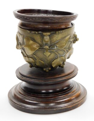 A Chinese bronze two handled cup, cast with leaves, berries, etc., mounted on a turned mahogany plinth, with a wooden lid, 15cm high overall. - 2