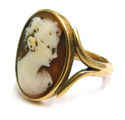 A late 19thC shell cameo ring, the oval cameo looking to the right, on shaped shoulders, yellow metal, stamped 9ct, ring size N, 5.1g all in.