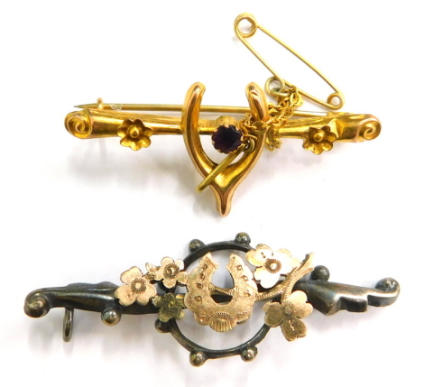 Two bar brooches, to include a yellow metal wishbone brooch, with amethyst central band and safety chain yellow metal unmarked, 1.2g, together with a silver horseshoe set brooch (2).