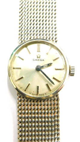 An Omega 9ct white gold ladies wrist watch, with a small circular silvered dial, on bark effect bracelet, 19cm long, with certificate for guarantee dated 1st June 1972, movement number 25749763, 35.5g all in.