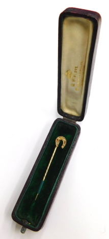 A horseshoe stick pin, the horseshoe top set with various sea pearls (two missing) in yellow metal setting, unmarked, and a later steel pin in a W Winlove box, 5cm high.