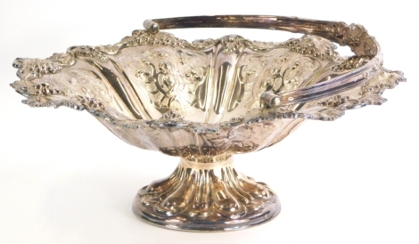 An Edwardian silver plated comport, of shaped form, repousse decorated with berries and scrolls, with swing handle, on a circular foot, 32cm wide, 4½oz.