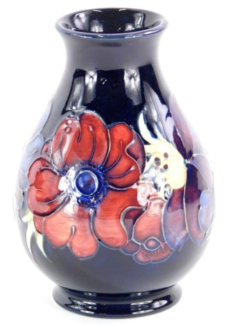 A Moorcroft baluster shaped vase, decorated with a band of poppies, on a blue ground, impress mark to underside, 13.5cm high.