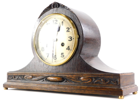 An early 20thC oak mantel clock, the silvered dial with Arabic numerals on bun feet, 43m wide.