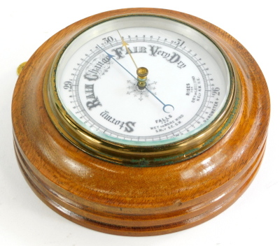 An early 20thC circular aneroid barometer, in an oak case, 20cm diameter.