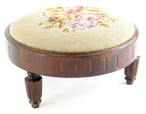 A mahogany circular footstool, on turned and fluted legs, label to underside for the Needle Woman Shop, Regent Street London.