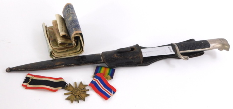 A German bayonet, the blade stamped Rich.Abr.Herber Solingen, with leather scabbard, a Third Reich 1939 merit award medal and German bank notes.