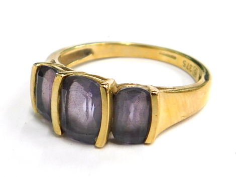 A 9ct gold dress ring, set with three oval cut amethyst, in a modern staged ring setting, ring size L½, 2.5g all in, boxed.