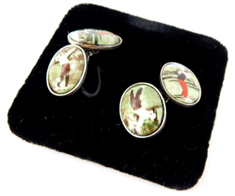 A pair of silver golfing related cufflink's, each depicting figures golfing, on silver backing with chain support, 10.6g all in.