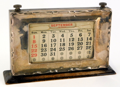 An early 20thC silver mounted and ebonised desk calendar, Birmingham assay, marks indistinct, 21cm wide.