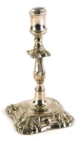 A silver taperstick in mid 18thC style, cast with scrolls, etc., loaded, unmarked, 12.5cm high.