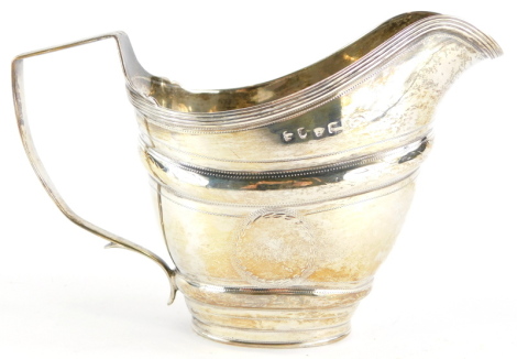 A 19thC silver helmet shaped cream jug, with circular engraved vacant cartouches, and reeded borders, marks indistinct, 3½oz.