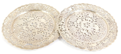 A pair of Eastern white metal plates, each with pierced and engraved decoration of animals, trees, leaves, etc., possibly Indian, unmarked, (AF), 5¾oz, 16.5cm diameter.