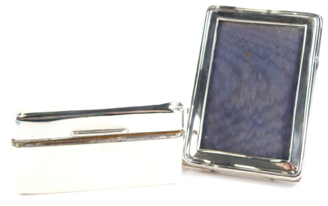 A silver mounted cigarette box, with cedar lined interior and weighted base, and a silver mounted photograph frame. (2)