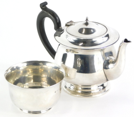 A George V silver bachelors type teapot, with ebonised handle and turned knop, and a matching sugar bowl, Birmingham 1932, 15½oz gross.