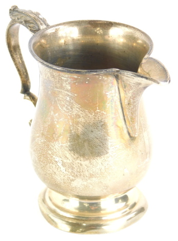 A George V silver baluster shaped milk jug, with a scroll handle and tapering foot, Birmingham 1932, 4½oz.