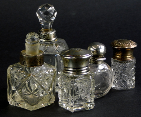 A collection of five cut glass dressing table items, to include a scent bottle with hinged lid and inner glass stopper, another scent bottle with silver collar, etc.