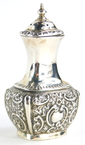 An Edwardian silver pepper pot, with embossed decoration of scrolls, around a central engraved cartouche, the reverse with vacant cartouche, Chester 1902, 2oz.