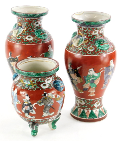 A late 19th/early 20thC oriental pottery garniture, comprising of a pair of baluster shaped vases decorated with figures and a similar jar. (jar lacking lid, AF)