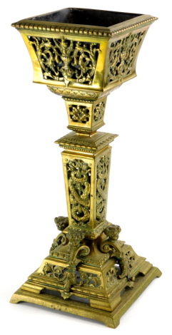 A late 19thC continental brass centrepiece, with pierced decoration, on a square base embellished with scrolls, caryatids, etc., 43cm high.