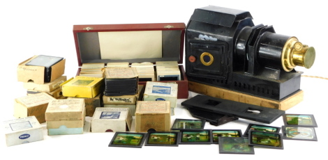 An ebonised and brass magic lantern and various magic lantern slides, mainly boxed, to include The Boy Scouts, British Navy, Peter Pan, Red Riding Hood, etc.