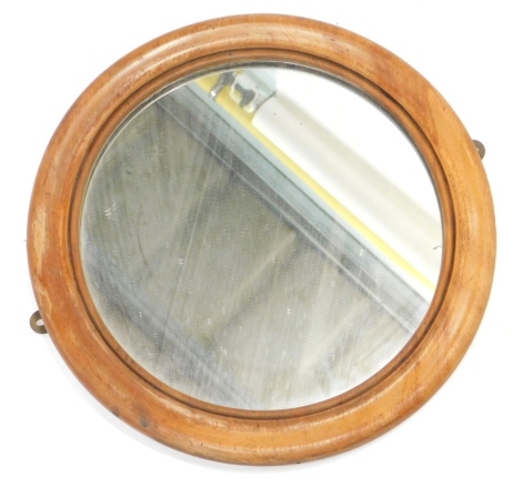 An unusual mahogany wall mirror, the reverse turned with a bullet hole or target decoration, 35cm diameter.