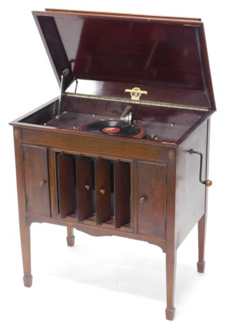 An early 20thC Columbia gramophone, in mahogany case with drawers containing 78 records and a central grill for the speakers, retailer's label for Felton's of Harrow, on square tapering legs, 76cm wide.