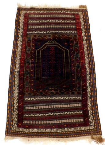 A Persian Turkamen type rug, with a central medallion in red, on a blue ground with striped design to each end, and multiple borders, 155cm x 90cm.