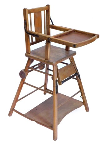 An early 20thC beech child's high chair, with adjustable shelf and a concave under tier.