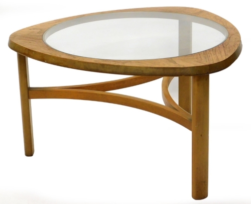 A Nathan triangular teak coffee table, with smoked glass insert, on part turned legs with concave undertier, 76cm wide.