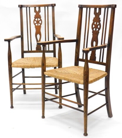 A pair of late 19thC Arts & Crafts style open armchairs, each with a pierced splat, a rush seat on turned tapering legs.