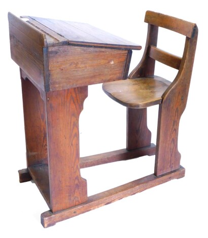 A late 19th/ early 20thC pitch pine and elm school desk, the hinged lid enclosing a vacant interior on plain runners, with integral seat.