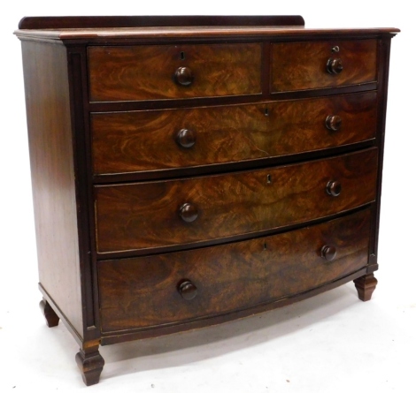 A Victorian figured mahogany bow fronted chest of drawers, with a raised back above two short and three long drawers, each with turned wood handles on block feet, 117cm wide.