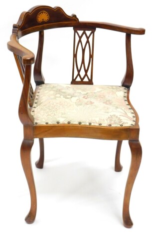 An Edwardian mahogany and boxwood strung corner chair, with a shaped back, pierced supports and padded seat on cabriole legs.