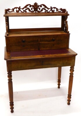 A 19thC French mahogany writing desk, the raised back with a pierced leaf carved gallery, above a shelf with a moulded edge on shaped supports, and four drawers, the canted base with a maroon sliding leatherette insert, above a frieze drawer on turned flu