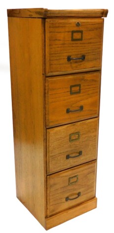 An early 20thC light oak filing cabinet, with metal fittings to the four drawers on plinth base, 208cm high, 41cm wide.