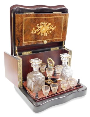 A walnut and ebonised liqueur cabinet, with musical marquetry serpentine panels and enclosing two gilt and cut glass decanters and twelve liqueur glasses, 26.5cm high, 33cm wide, 26cm deep.