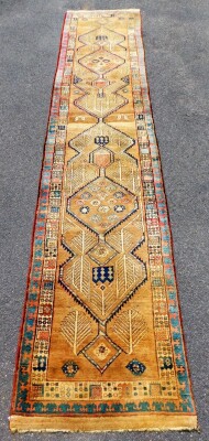 An early 20thC Sarab design carpet runner, with two stylised borders, enclosing a central floral medallion field, with trees, 460cm x 86cm.