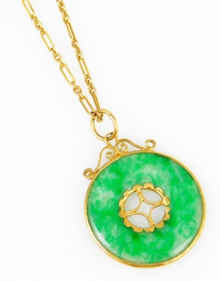 A jade circular pendant and chain, the pendant with cut out centre and gold applied decoration, on a yellow metal chain, the clasp marked 9c, chain 24cm long, pendant 2.5cm wide, 7.5g all in.