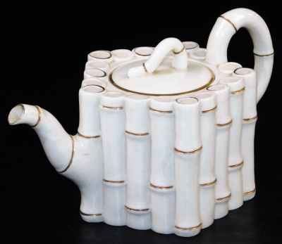 A first period Belleek bamboo moulded teapot and cover, black first period mark, the moulded body in the form of bamboo stems, 12.5cm high. (2) For a similar example see Belleek Irish Porcelain page 12.