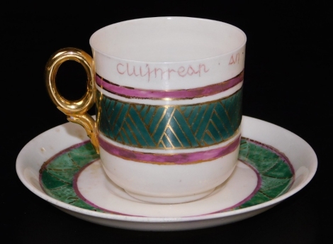 An unusual second period Belleek polychrome tea cup and saucer, decorated with a green ground band between puce moulded borders and cross hatched gilding, inscribed Cuijnreap.an.cl'alpread. pair, second period black mark.