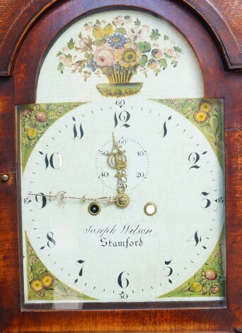 Joseph Wilson of Stamford. A Georgian grandmother long case clock, the break arch dial painted with flowers and fruit, dial bearing Arabic numerals, subsidiary seconds dial, two train eight day movement, with bell strike, the hood with a break arch pedime