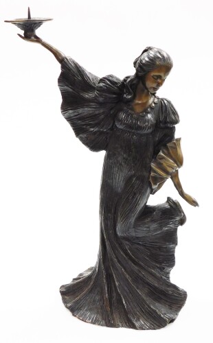 A contemporary bronze figured candlestick, of a standing female, in a long flowing dress and holding a aloft a pricket candle sconce, 51cm high.