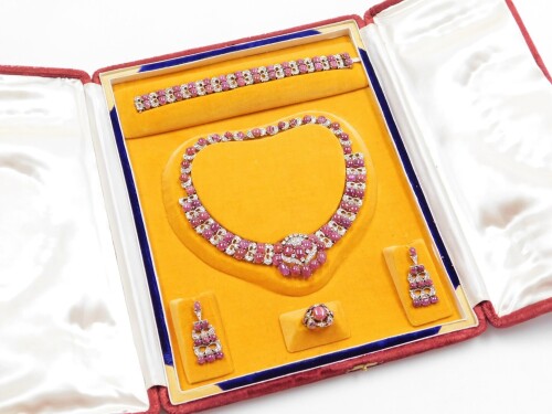 An Indian wedding jewellery suite, comprising necklace, bracelet, earrings and ring, each set with rows of cabochon rough cut rubies and white diamond imitation stones, possibly white sapphires, in white metal casing, with gilt applied detailing to under