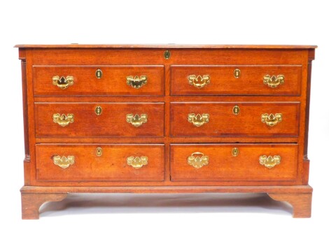 A George III oak and mahogany cross banded Lancashire chest, with a hinged top above four dummy drawers and two frieze drawers, raised on bracket feet, 92cm high, 156cm wide, 55.5cm deep.