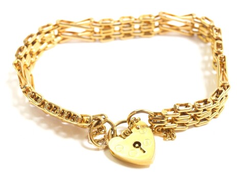 A 9ct gold three bar fancy link gate bracelet, on a heart shaped padlock clasp, with safety chain as fitted, 21.2g.