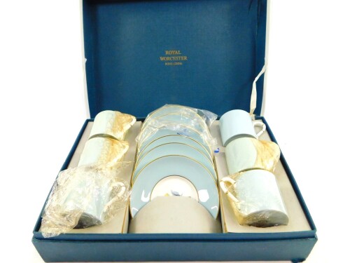 A Royal Worcester porcelain coffee set decorated in the Woodland pattern, comprising six demi-tasse coffee cans and saucers, boxed.