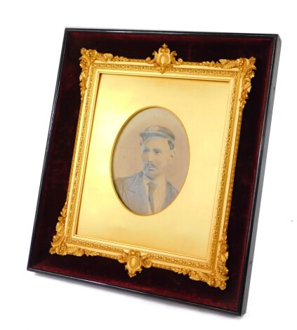 A Victorian gilt wood and gesso strut photograph frame, red velvet backed within an ebonised outer frame, decorated with cartouches, flowers and leaves, containing a half length portrait of a gentleman, aperture 18.5cm high, 14cm wide, outer frame 44cm hi