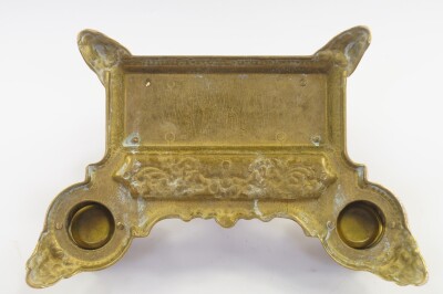 A Victorian rococo style brass desk stand, cast with cherubs, winged beasts and vase of flowers, having a letter rack pen tray and double ink wells, 30cm wide. - 3