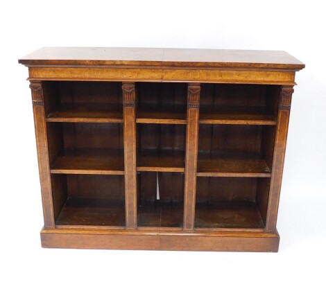 A Victorian walnut and satin wood cross banded open bookcase, with six open shelves, and four column uprights, raised on a plinth base, 106cm high, 134.5cm wide, 40cm deep.